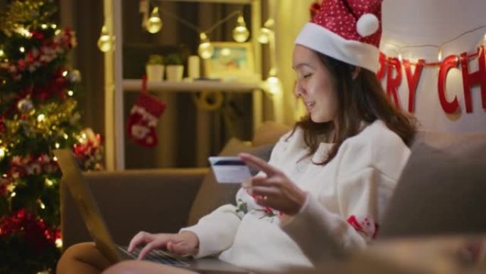 女人在圣诞节使用笔记本电脑和卡片在线购买