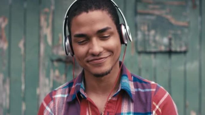 一个年轻人在城市背景下使用耳机的4k视频片段