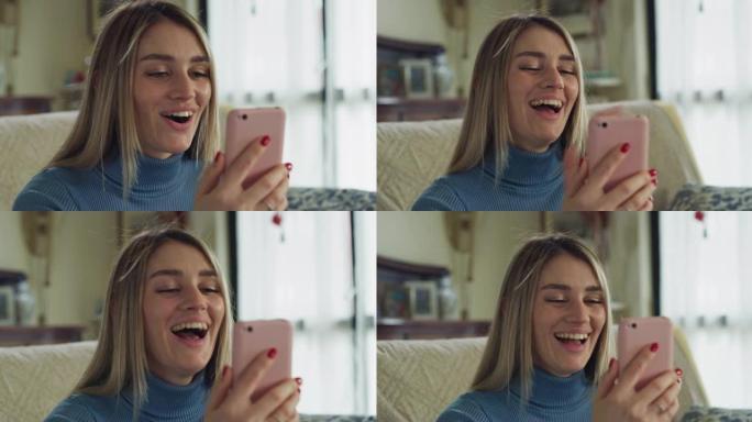 年轻快乐的微笑女人的真实镜头，坐在家里的客厅沙发上，用智能手机向朋友或家人进行技术视频通话。连接，交