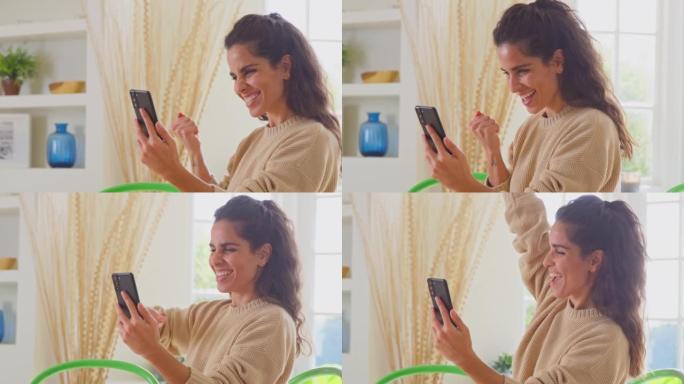 在家庆祝女人在手机上获得好消息-慢动作拍摄