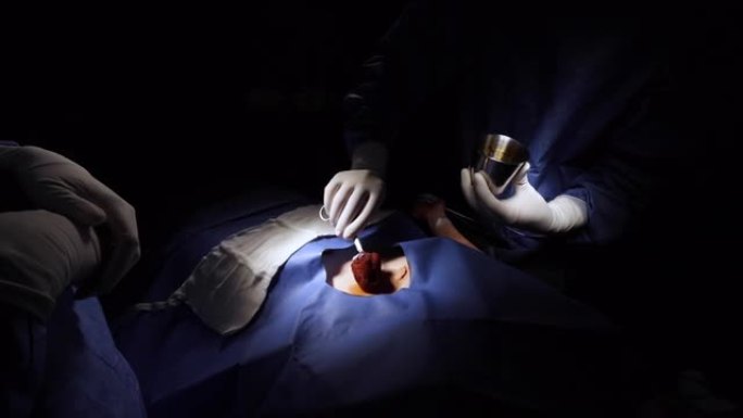 外科医生在手术期间用手术刀切割前清洁患者的皮肤
