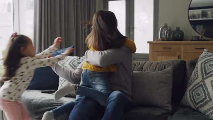 两个小女孩在家里沙发上拥抱父亲的4k视频片段