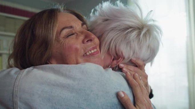快乐的高级祖母和孙女的电影镜头在一起玩得开心，并在家里的客厅里拥抱。概念: 生活，祖父母，世代，爱，