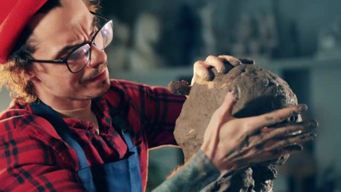 创意、设计、工艺工作理念。男艺术家正在用手塑造一块粘土