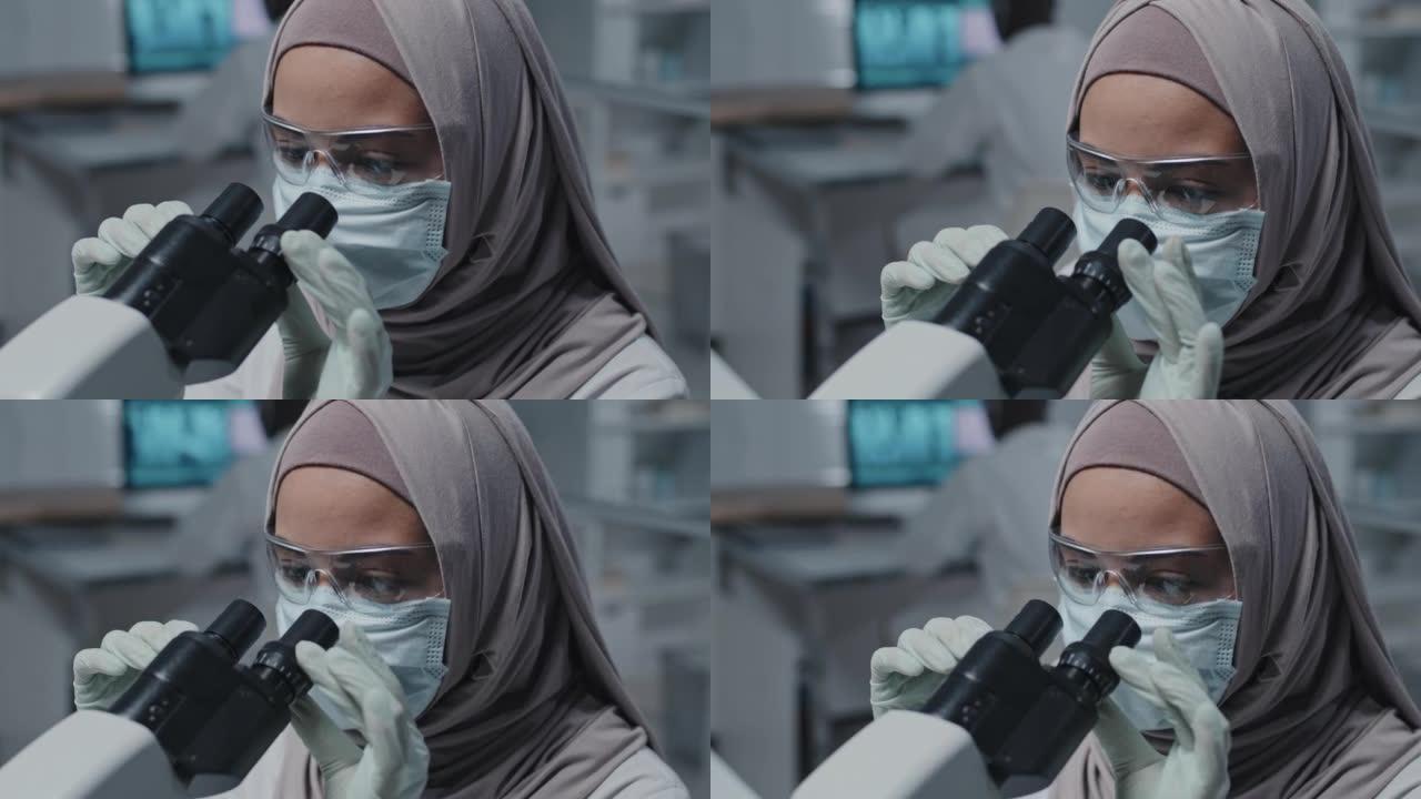 穆斯林实验室技术员使用显微镜