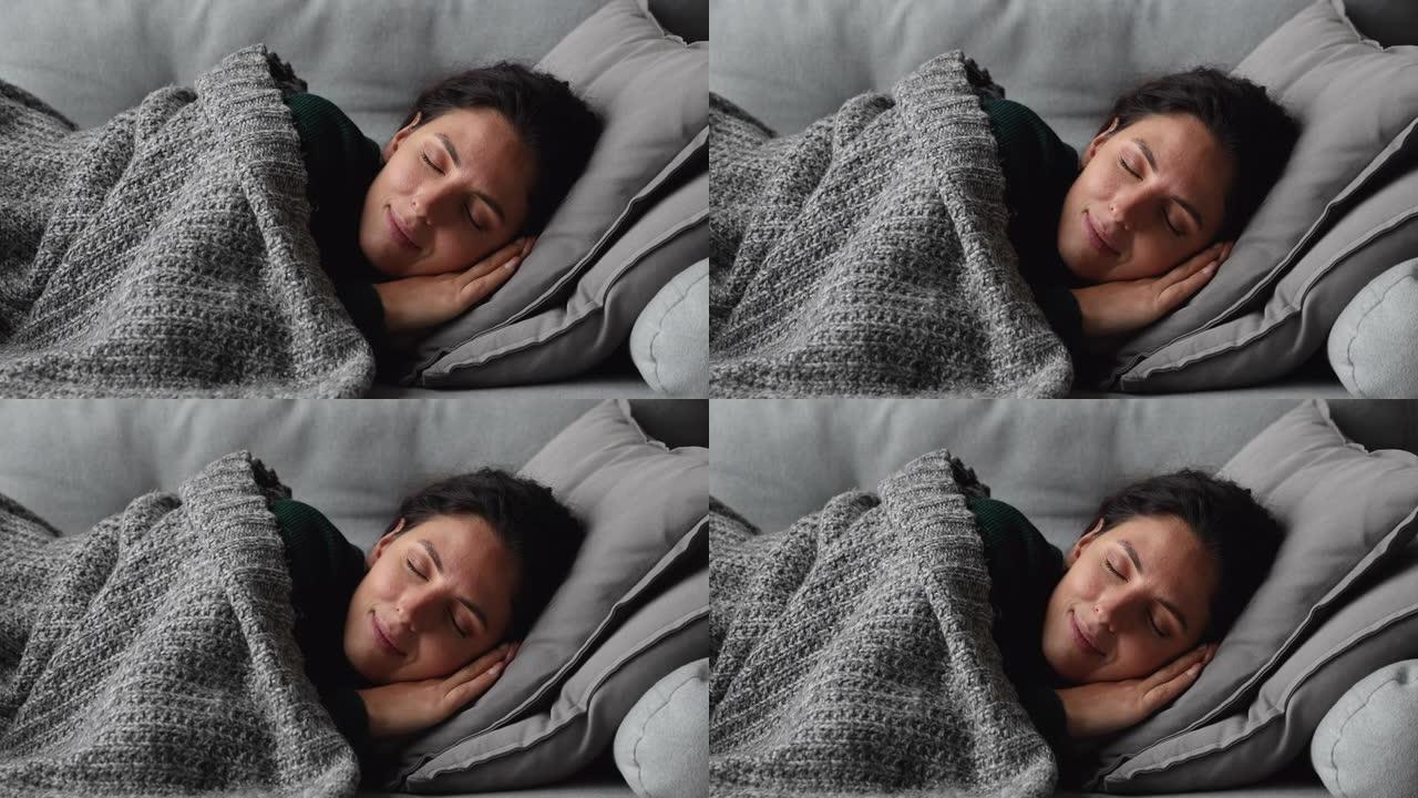 躺在沙发上的温暖针织格子覆盖着睡觉的女人