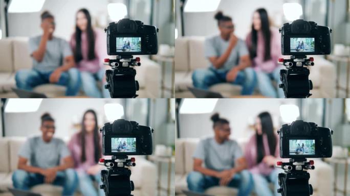 摄影机正在摄影棚拍摄一对年轻夫妇。在线vlog，博客录制视频，在线流媒体概念。