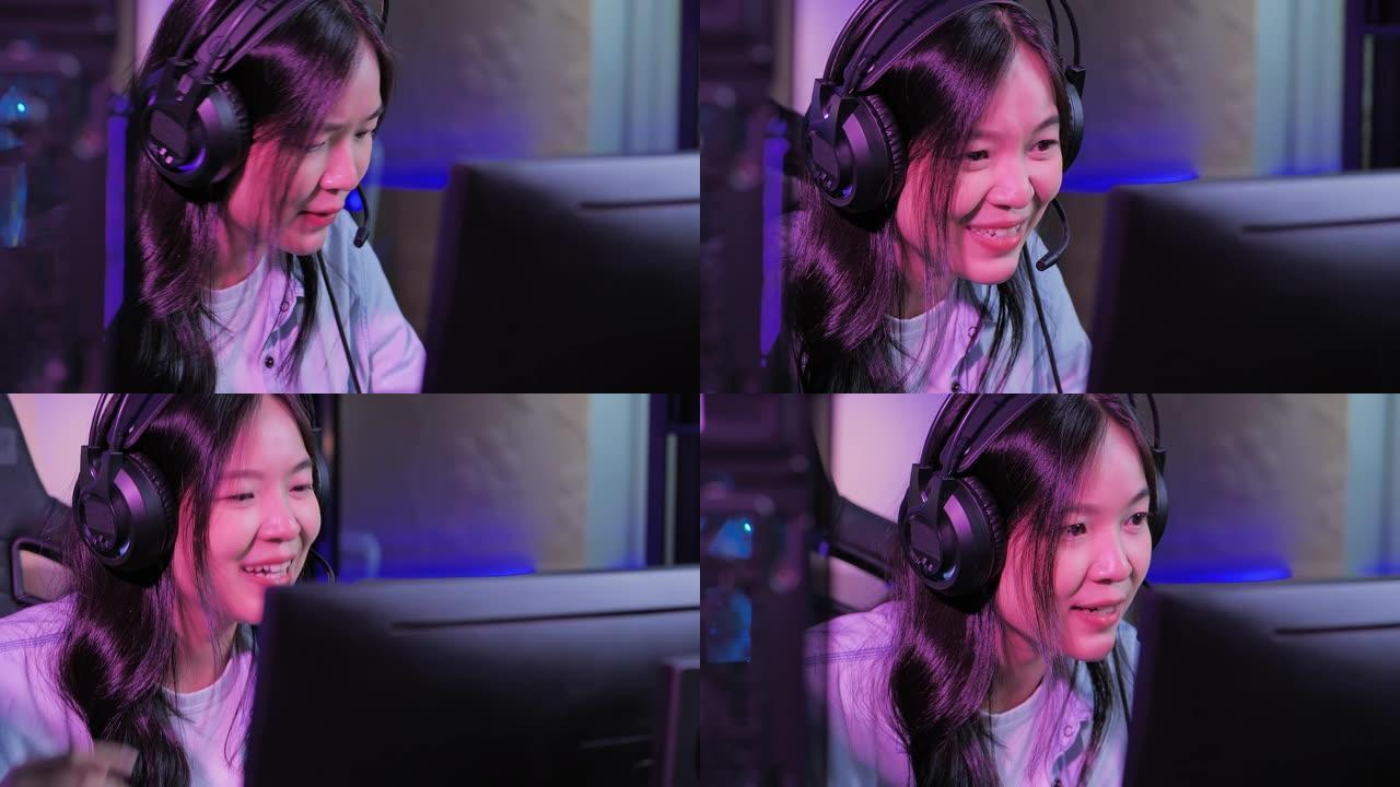 激动的千禧一代和Z世代的亚洲少女使用电脑与其他玩家在网上视频游戏中交谈，晚上在彩色紫外线照明客厅，呆
