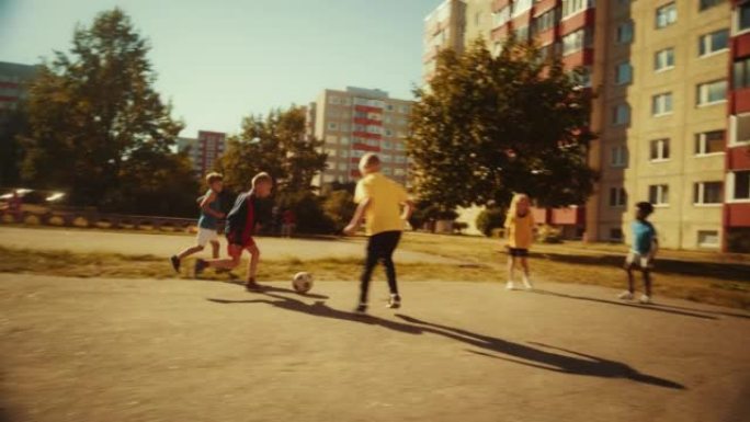 附近的孩子们在阳光明媚的后院外面踢足球。年轻的天才足球运动员运球，进球。男孩和女孩拥抱，庆祝胜利。宽