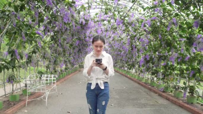 亚洲美丽的少女在公园使用智能手机