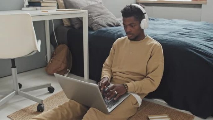 非裔美国人在卧室里用笔记本电脑工作