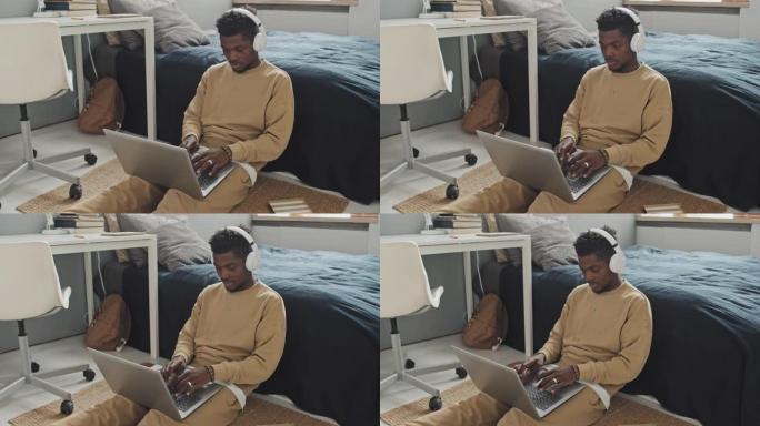 非裔美国人在卧室里用笔记本电脑工作