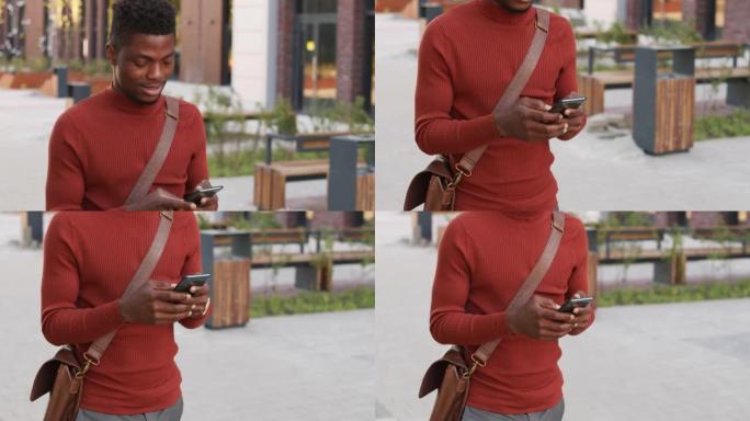 非裔美国商人在市区散步时使用智能手机