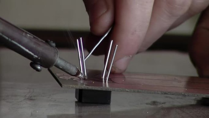 在为阿根廷监狱的囚犯上课期间，电子工程师用烙铁做了一个小电路。特写。