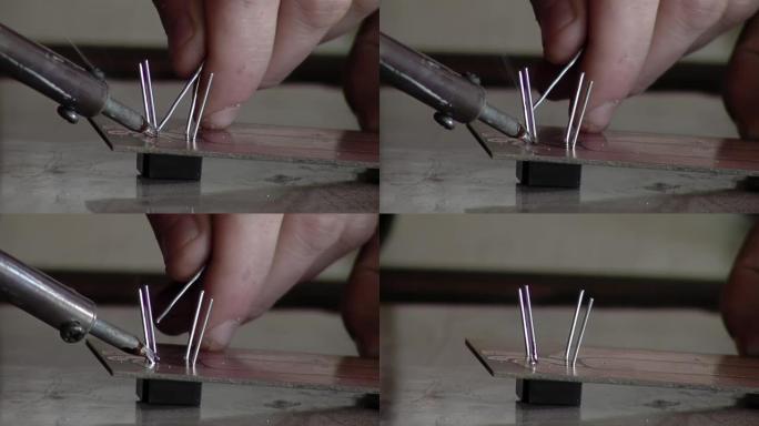 在为阿根廷监狱的囚犯上课期间，电子工程师用烙铁做了一个小电路。特写。
