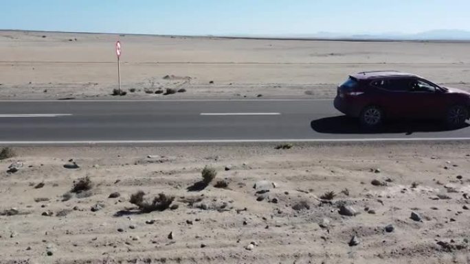 无人机拍摄的SUV汽车在阿塔卡马沙漠中行驶的镜头，阿塔卡马沙漠是世界上最干燥的非极地沙漠，智利，南美