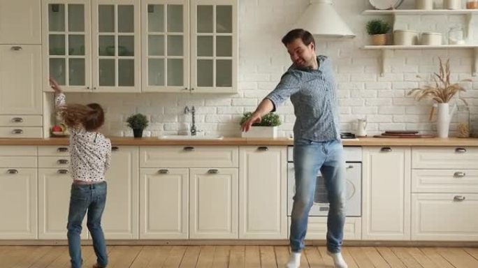 幸福的两代人在厨房里一起跳舞。