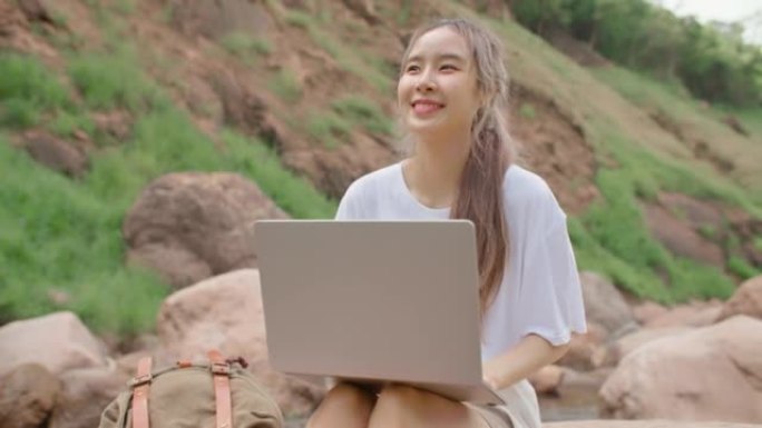 女性自由职业者在美丽的大自然旅行时使用笔记本电脑远程工作。