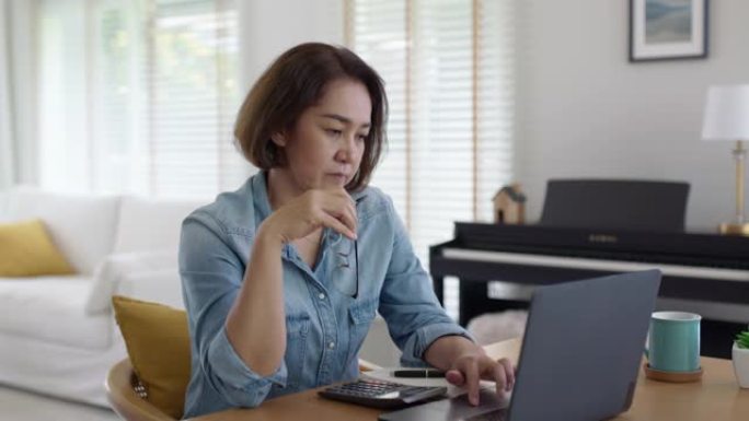亚洲成熟女性深思熟虑的压力乏力担心在家中的远程工作