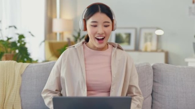 女人，耳机和笔记本电脑与优胜者在家庭沙发上庆祝，并为赢得在线比赛感到兴奋。女性对韩国拍卖或投资的网站
