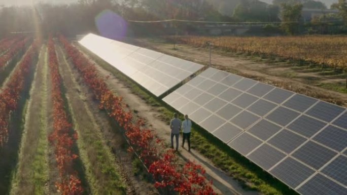太阳能，团队合作和农场与一名男女工程师走在农业土地上，以维持太阳能电池板组。农业、合作和可再生能源与