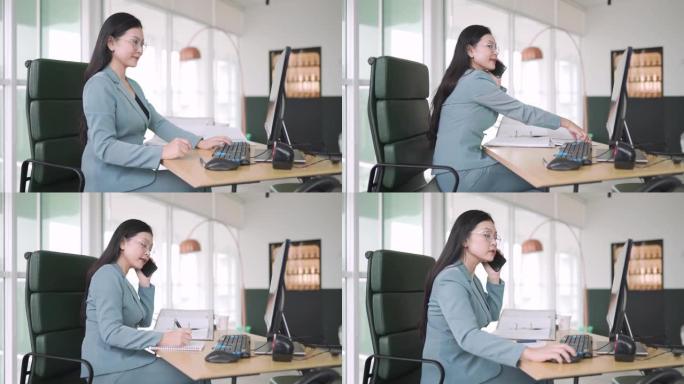 亚洲华裔女性行政管理人员坐在她的办公室在台式电脑前工作