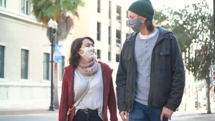 年轻夫妇在城市散步，戴着口罩