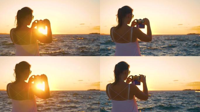 特写: 在扎达尔度假的年轻女子正在拍摄日落的照片。