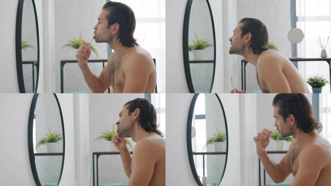 公寓里刷牙和看浴室墙上镜子的家伙的侧视图