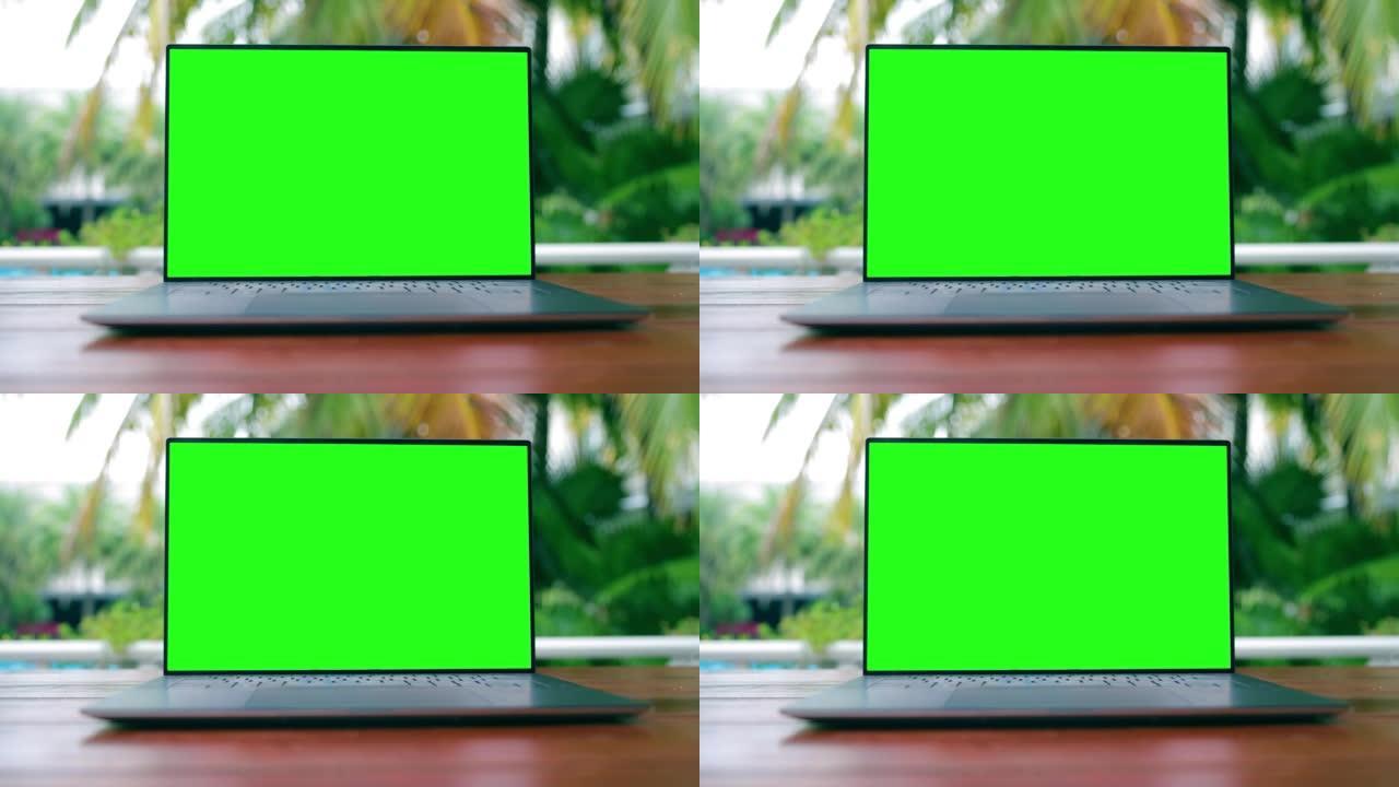 户外木桌上绿屏笔记本电脑