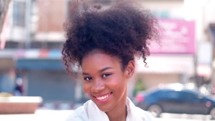 画像美丽的年轻黑人妇女与爆炸头的头发在城市