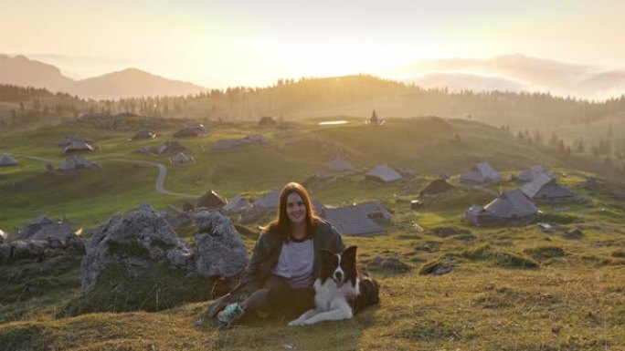 年轻女子的肖像，宠物狗坐在山上