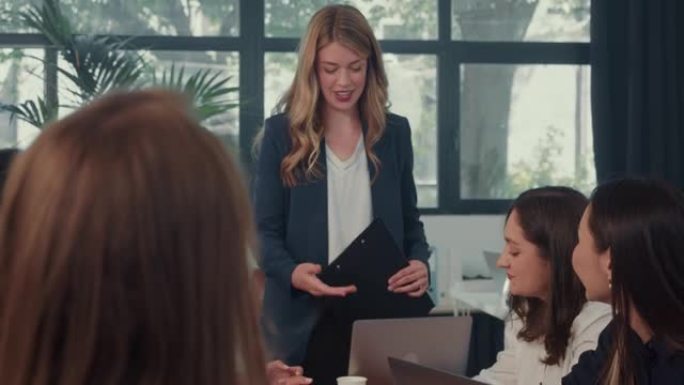 年轻的女老板，执行团队负责人在办公室桌子会议慢动作上与快乐的多元化同事交谈。