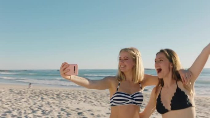 最好的朋友在海滩上自拍，使用智能手机少女分享暑假，享受海边的夏日时光