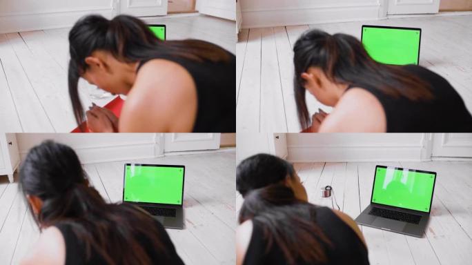 女人在锻炼时看着笔记本电脑 -- 色度键绿色屏幕