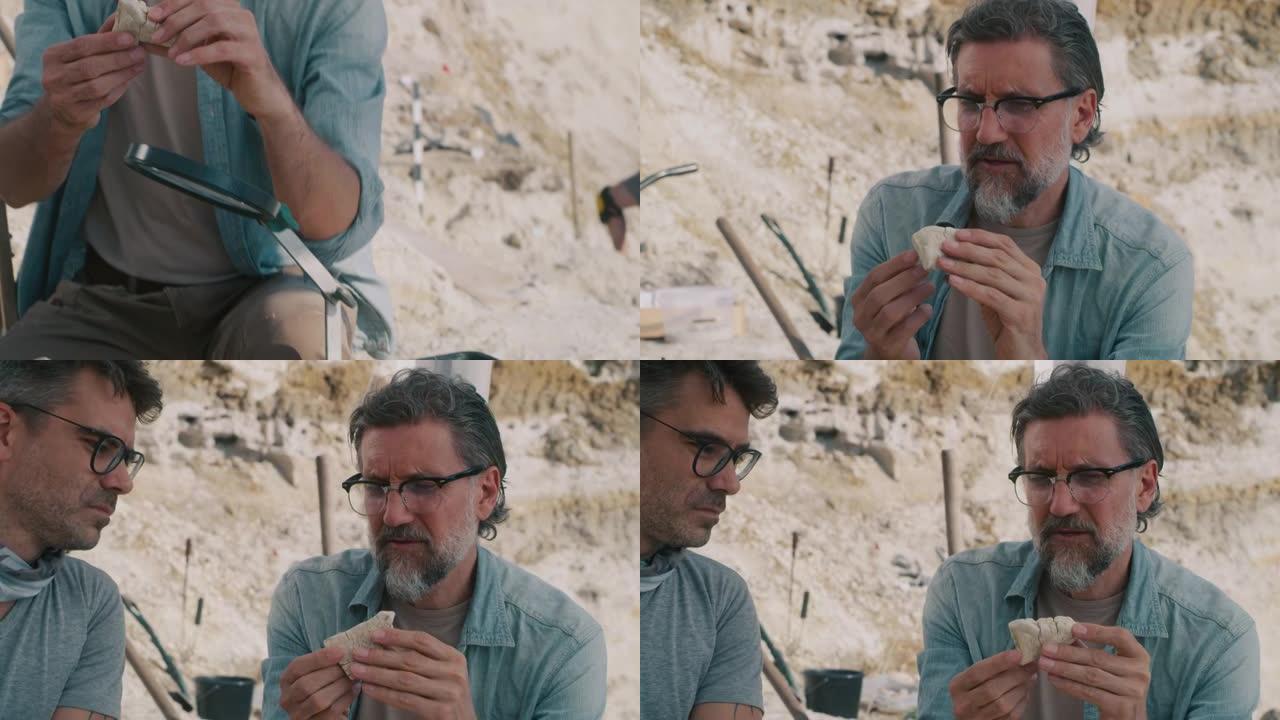 成熟的男人在考古现场分析石头