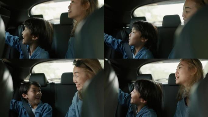 小男孩和母亲在汽车后座上微笑着跳舞