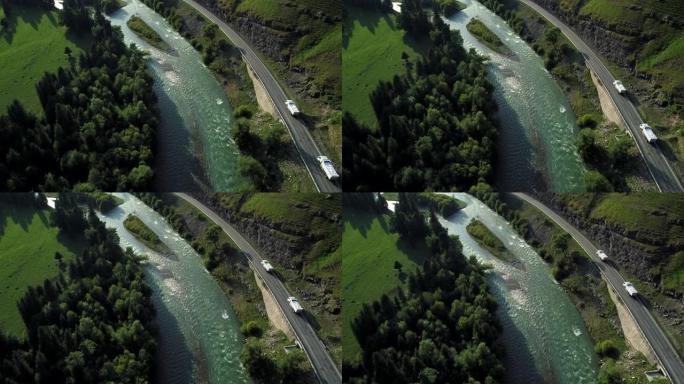 蜿蜒的河流旁的高速公路上行驶的汽车俯视图