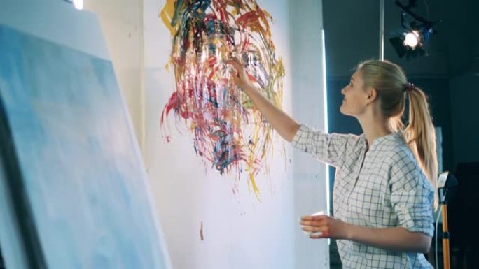 快乐的女人在艺术工作室用手绘画