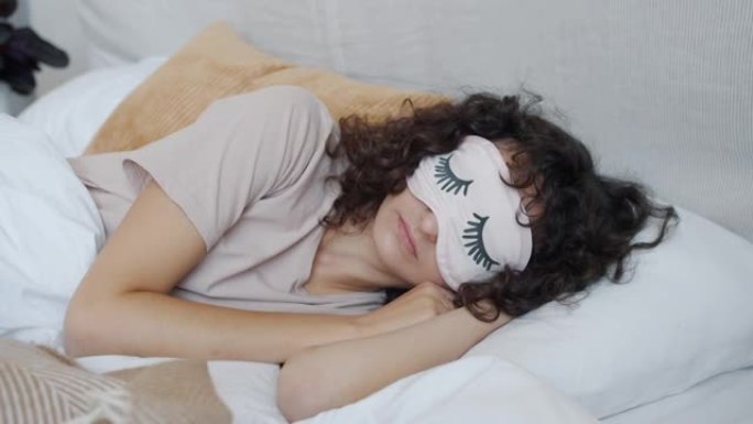 年轻女子戴着眼罩睡觉躺在床上的肖像