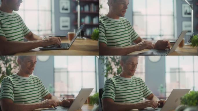 英俊的白人男子坐在办公桌前在笔记本电脑上进行远程在线工作的肖像。自由职业者在家工作。基座弧形中射