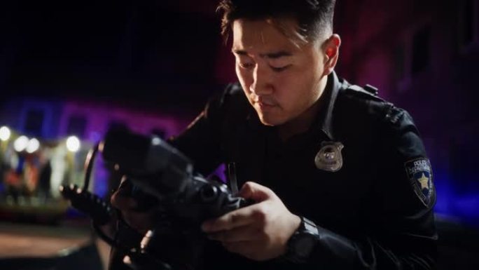 特写镜头:亚裔男警察在夜间犯罪现场拍照。职业青年警察实地调查，办案，拍摄罪犯留下的证据和线索