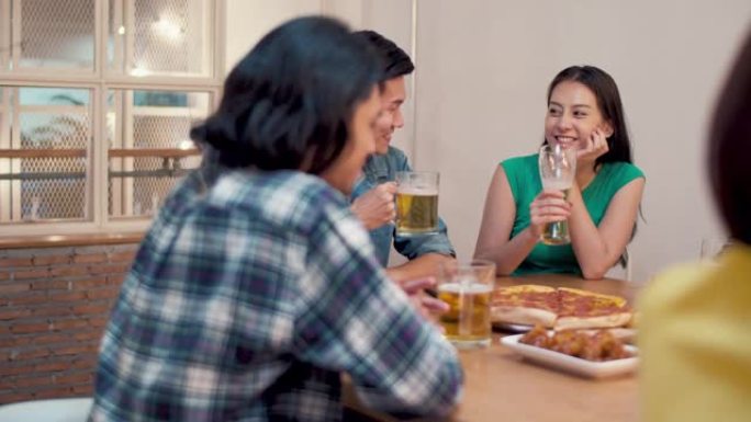 团体快乐的亚洲朋友在家里享受啤酒，朋友用餐和派对概念