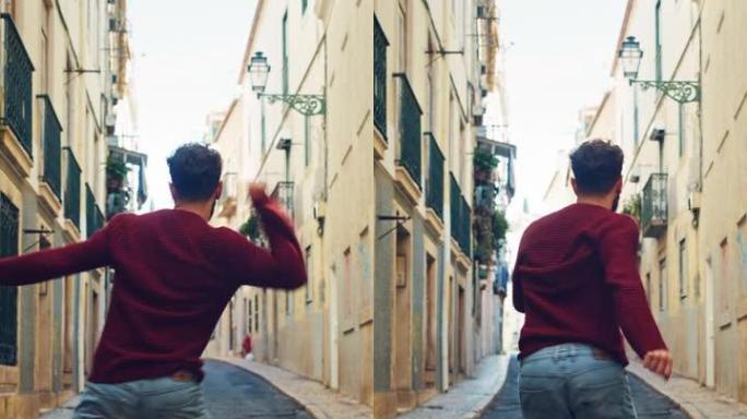 垂直屏幕: 穿着休闲服装的开朗的成年男子在城市老城区的街道上散步时积极跳舞。在安静的小镇街道上的城市