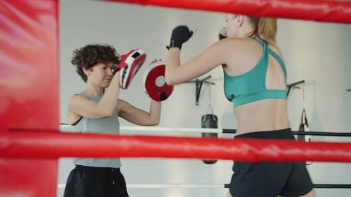 年轻女子跆拳道，女教练在健身房练习踢和拳