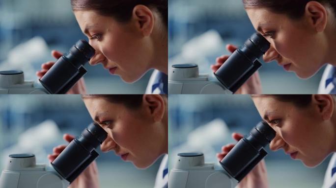 宏观特写一位美丽的女科学家看着显微镜的镜头。用技术设备在现代实验室中研究分子样品的女性微生物学家。