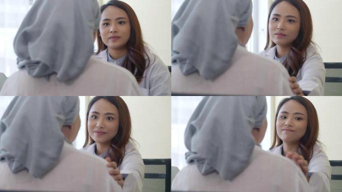 亚洲女医生的后视图，用化学疗法引起的癌症用布遮住头，用肩膀触摸女人，有助于表达同情，鼓励在医院就诊。