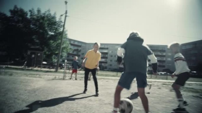 在东欧后院踢足球的邻居孩子。年轻的足球运动员运球，进球。男孩和女孩拥抱，庆祝胜利。冷去饱和颜色分级。