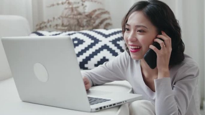 使用笔记本电脑在家工作的年轻亚洲妇女