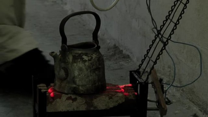 囚犯在阿根廷布宜诺斯艾利斯省最高安全监狱内的乡村电炉上加热水。特写。